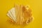 Assorted types of pasta on yellow background.