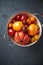 Assorted varieties of tomato in a colander