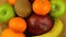 Assorted various fruits rotates on a wooden board. View from above.