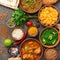 Assorted various Indian food on a dark rustic background. Traditional Indian dishes - Chicken tikka masala, palak paneer, saffron