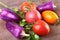 Assorted vegetable with purple exotic color bell peppers and tomatoes isolated on stone background.