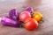 Assorted vegetable with purple exotic color bell peppers and tomatoes on stone background.