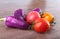 Assorted vegetable with purple exotic color bell peppers and tomatoes on stone background.