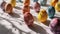 Assorted Watercolor Easter Eggs with Dramatic Shadows on Textured Surface