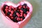 Assorted wild berries in gift red box in the form of heart