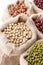 Assortment of beans and lentils in hemp sack on wooden background. green bean, groundnut, soybean, red kidney bean , black bean ,