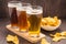 Assortment of beer glasses with nachos chips on a wooden table