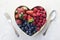 Assortment berries blueberries, strawberries and raspberries in heart woden box. Keto diet, detox, healthy food