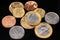 An assortment of Brazilian coins on a black reflective background