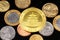 An assortment of Brazilian coins on a black reflective background with a Chinese one ounce gold coin