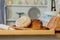 Assortment of breads near a wicker basket on a table in a rustic kitchen. Composition in kitchen at the photo studio