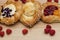 Assortment of cheese danishes puff pastry with blackberries, vanilla custard, cherry jam and fresh raspberries on wooden backgroun