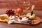 Assortment of cheese with fruits, grapes, nuts, glass with wine and cheese knife on a wooden serving tray
