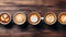 Assortment of colorful coffee mugs arranged neatly on a rustic wooden table top view shot