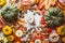 Assortment of colorful farm pumpkins with mug of hot chocolate, nuts , spices and autumn leaves, top view. Autumn still life with