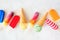 Assortment of colorful summer popsicles and ice cream desserts scattered on white marble