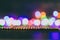 Assortment of coloured pencils on dark background with psychedelic multicolor string lights creating rainbow bokeh