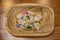 Assortment of crystals and stones of different colors and textures in a carved wooden bowl sitting on a wood plank surface - top