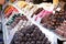 Assortment of delicious chocolate candies for sale on counter of shop, market, cafe. Variety of marzipan candy balls on the store