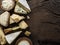 Assortment of different cheese types on wooden background. Top view