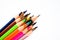 Assortment of different colored pencil crayons pointing up on a white background