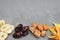 Assortment of Dried Fruits: Banana, Ginger, Mango over Gray Background with copy space.