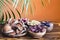 Assortment of dry herbal healthy tropical tea in wooden bowls and palm leaf on rustic background