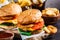 Assortment of fast food. Junk food background. Cheeseburgers, french fries, nachos, donuts, soda and nuggets on dark background