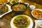 An assortment of Filipino cuisine on a wood table at a local restaurant. Included in photo - Pork belly in peanut sauce, shrimps,