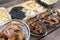 An assortment of food items on a wooden bench: Flavored Chicken wings, Chicharon Bulaklak, Baked Nachos and Baked Sushi. Outdoor