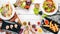 Assortment of food, salads with shrimp and meat. On a wooden background.