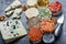 Assortment of French fresh white soft goat cheeses with different tastes topping made with herbs, paprika, indian curry, bruscetta