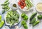 Assortment of fresh garden vegetables - asparagus, broccoli, beans, peppers, tomatoes, cucumbers, garlic, green peas on a light ba