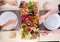 Assortment of fried meat, potatoes, sausages, pickles, tomatoes, peppers, herbs, lavash on a wooden tray on the table