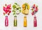 Assortment of fruit and vegetables smoothies in glass bottles with straws on white wooden background.