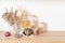 Assortment of grains, cereals and pasta in glass jars and vegetables on wooden table