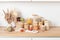 Assortment of grains, cereals and pasta in glass jars and vegetables on wooden table