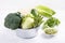 Assortment green vegetables on white table.  Broccoli, cauliflower, brussels sprouts, kohlrabi, avocado, asparagus, spinach,