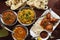 Assortment of Indian dishes for dinner, butter chicken, tikka masala, rice and naan