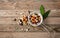 Assortment of legumes in a stainless drainer and spilled on a wooden tabletop background, top view.