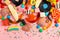 assortment of lollipops, fruit bonbon, candies and sprinkles on pink like background, copy space