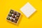 Assortment of luxury bonbons in box on bright yellow background