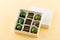 Assortment of luxury bonbons in box on pale yellow background