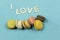 Assortment of multi-coloured macaroons on a blue background with the words I love