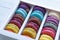 Assortment of multicolored macaroon different lie in the cardboard box with the top view