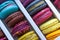 Assortment of multicolored macaroon different lie in the cardboard box with the top view. Close-up