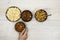 Assortment of nuts in metal bowls hazelnuts, walnuts, almonds and hand holding one bowl