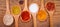 Assortment of powder spices on spoons on wooden background