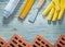 Assortment of red bricks safety gloves palette knife blueprints
