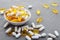 Assortment scattered pharmaceutical medicine vitamins, pills, drugs in bowl on gray background. White food dietary